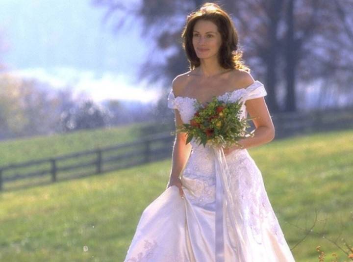 Julia Roberts in a wedding dress waling through a field in Runaway Bride.