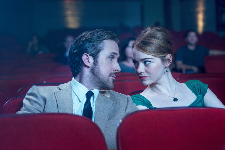 Ryan Gosling and Emma Stone looking at each other in the cinema in La La Land.